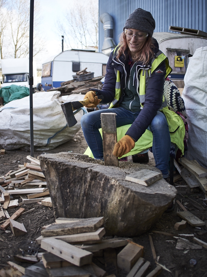Volunteer chopping wood for Calais refugees.
