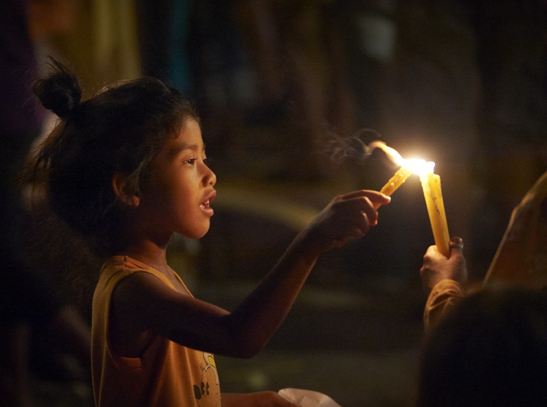 Girl lighting candles.