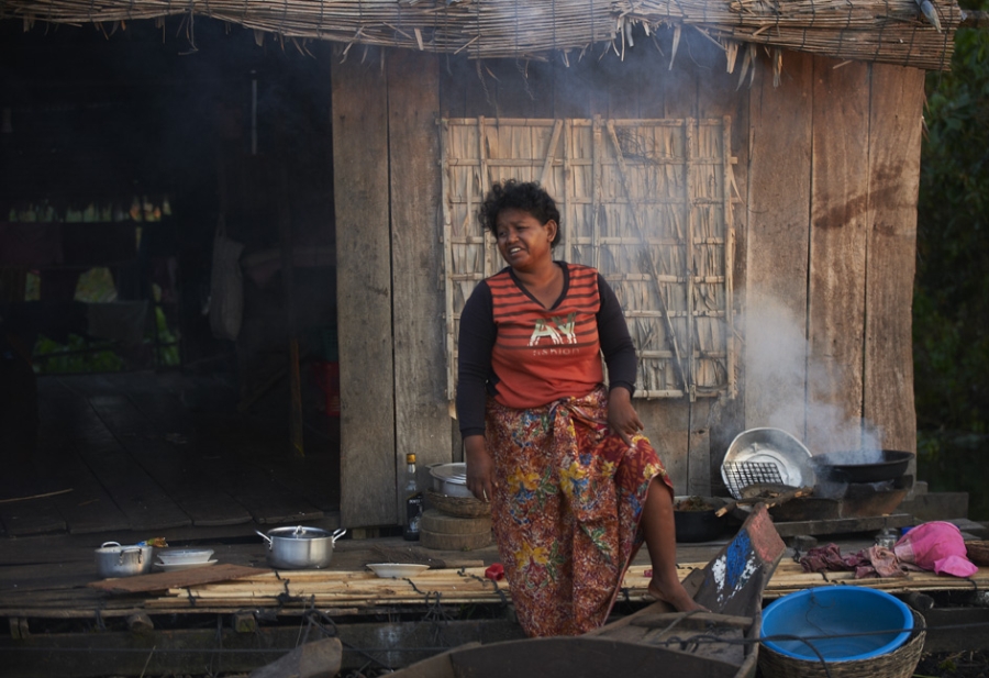 Woman cooking at home in floating village in Siem Reap.