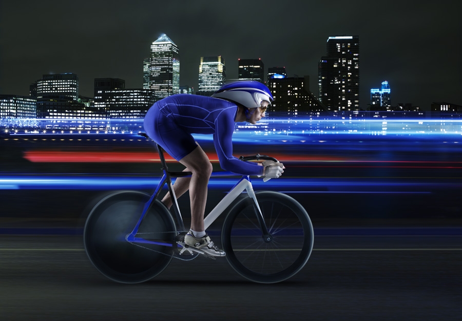 Cyclist performing against backdrop of Canary Wharf.