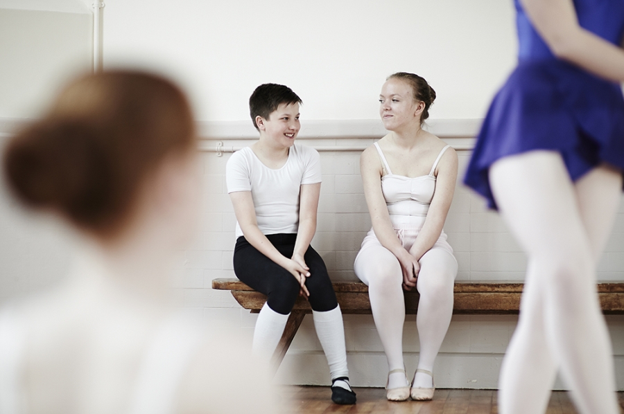 Two ballet pupils converse during a break in their class.