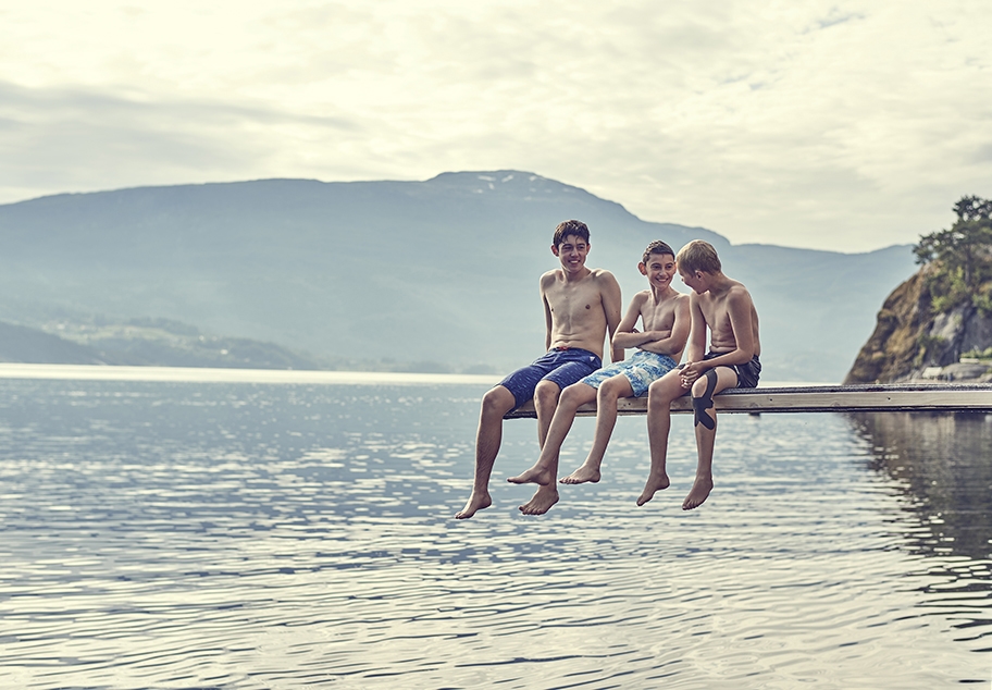 Young Males talking on Diving Board over Norwegian Fjord