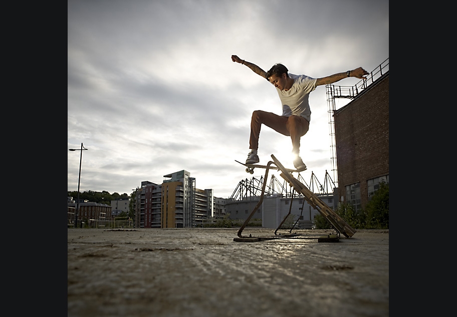 Skateboarder jumping over ramp