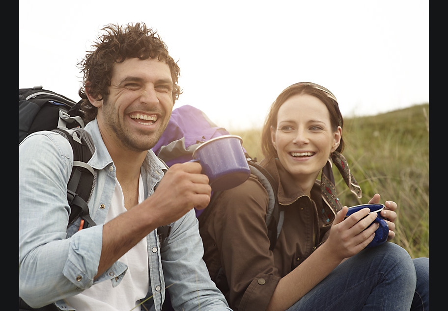 Male and female hikers drinking a cup of coffee